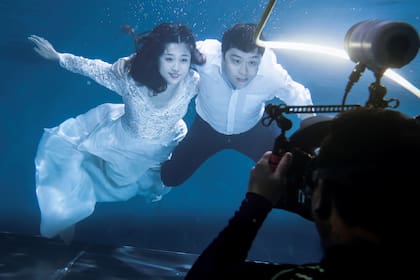 Cao Ri y Xu Jiaqian se toman una fotografía de la boda en una piscina en el estudio subacuático en Pekín, China,