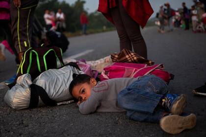 Issac de cuatro años descansa en medio de la calle en una para de de la caravana