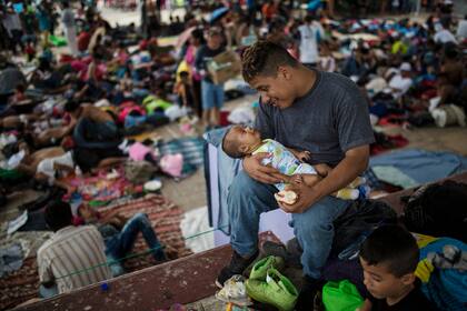 José Luis Ramos, juega con su hijo Froilan de 3 meses en la plaza central de Mapastepec