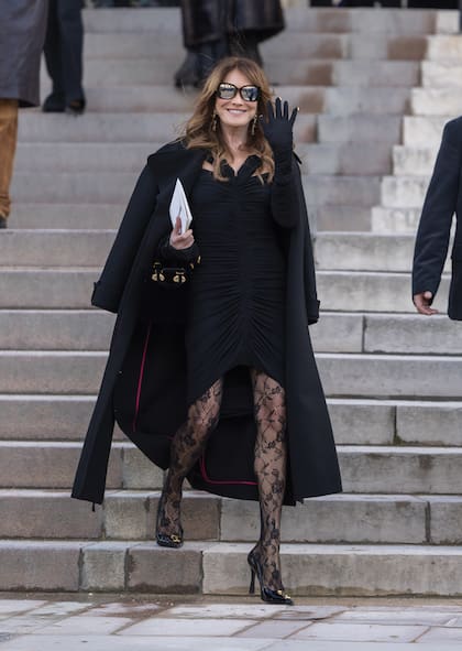 Carla Bruni eligió un vestido drapeado, de corte asimétrico, al que le dio un toque con medias de encaje, un recurso que suma últimamente en sus looks.