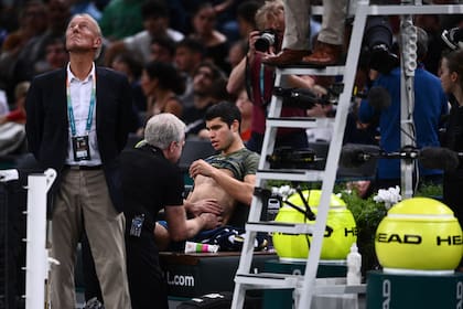 Carlos Alcaraz es atendido en el abdomen durante su partido por los cuartos de final del Masters 1000 de París-Bercy, frente a Holger Rune; en el tie break del segundo set decidirá no continuar.