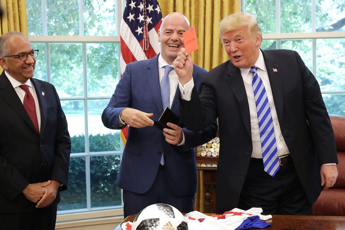 Carlos Cordeiro observa al costado mientras Trump saca una tarjeta roja; Gianni Infantino se ríe