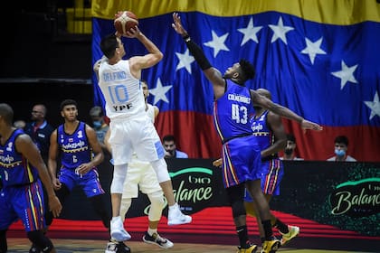 Carlos Delfino lanza ante la marca de Néstor Colmenares, con la escenografía de una enorme bandera venezolana en Obras Sanitarias; Venezuela se impuso por 13 puntos en la eliminatoria para el Mundial de Filipinas, Indonesia y Japón.
