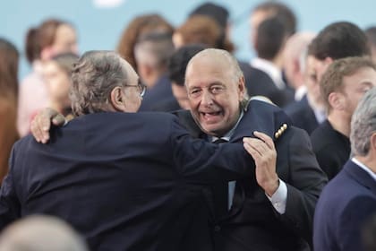 Carlos Heller se abraza con José Luis Manzano en el acto de asunción de Massa