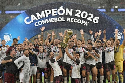 Carlos Izquierdoz y Eduardo Salvio (11) levantan juntos el trofeo de la Recopa Sudamericana tras ganarle a Flamengo en la Argentina y en Brasil; el equipo argentino festejó en un Maracaná que se vació pronto, bajo el diluvio