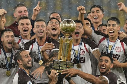 Carlos Izquierdoz y Eduardo Salvio levantan el trofeo con el plantel
