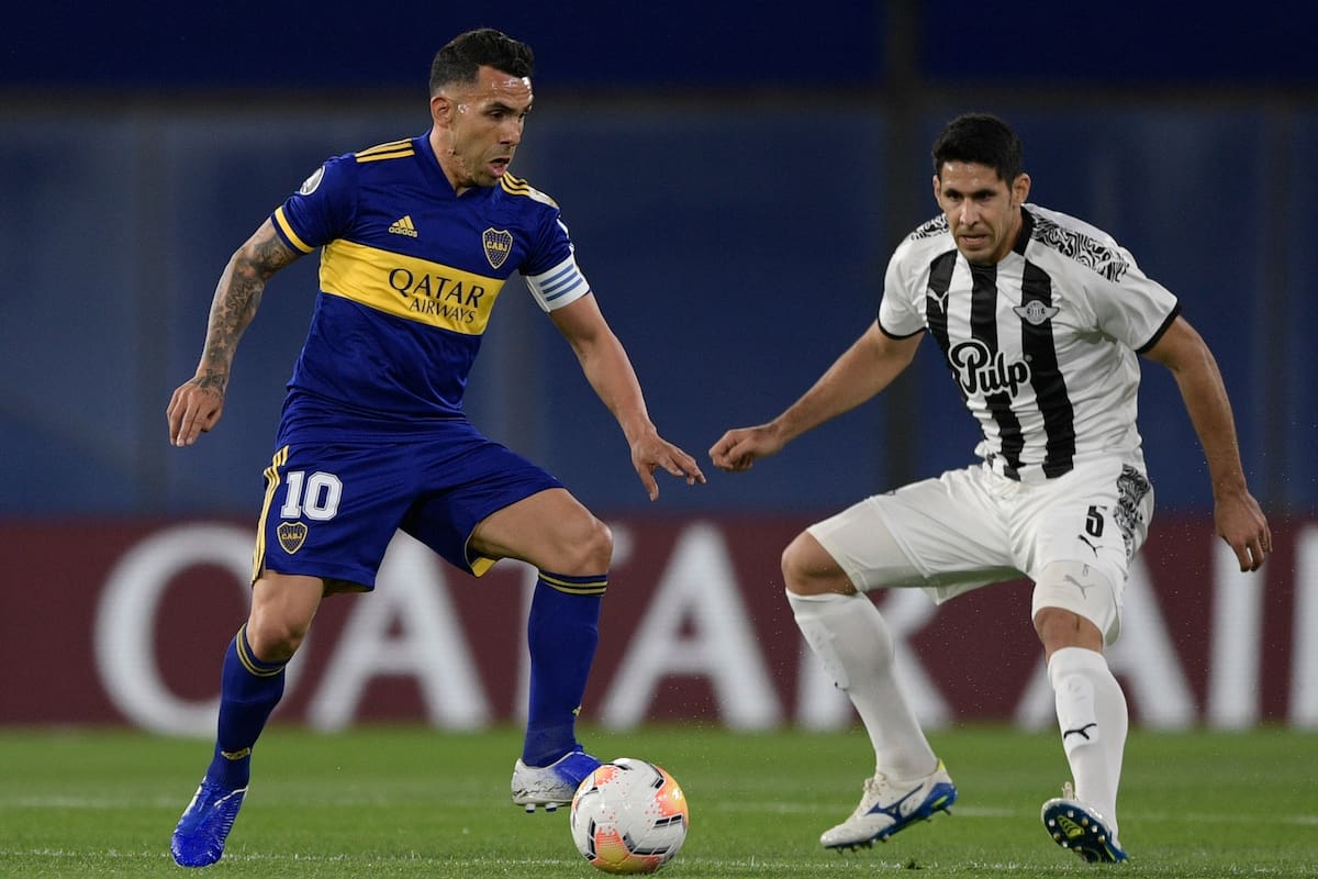 Carlos Tevez de Boca Juniors disputa la pelota con el defensor Diego Viera de Libertad