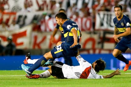 Carlos Tévez y Leo Ponzio luchan en el superclásico