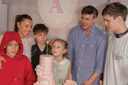 Carolina “Pampita” Ardohain y sus
hijos Benicio, Beltrán y Bautista
Vicuña, y Roberto García Moritán,
rodean a la cumpleañera, lista para
soplar las velitas en su torta de tres
pisos