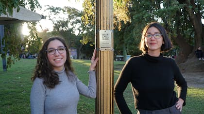 Carolina Repetto y Francisca Uloa, creadoras de BAenFoco, junto a un poste donde se encuentra uno de los códigos QR del proyecto