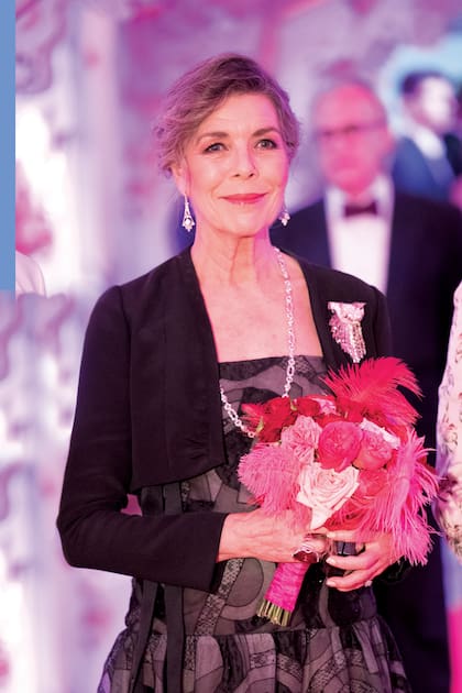 Carolina también lució un vestido de la colección Alta Costura Primavera-Verano 2022 de Chanel, con referencias a los años 20: un traje negro con estampado de círculos y falda globo recogida con un lazo que continúa plisada hasta los pies. Complementó su estilismo con pendientes largos y un collar de brillantes formando eslabones, y dio el toque final con una chaqueta corta negra.
