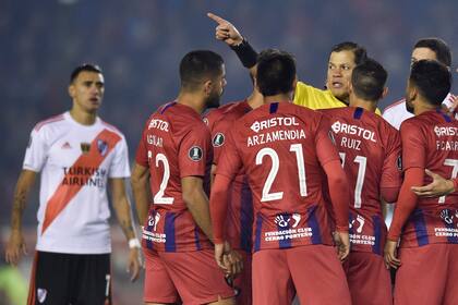 Carrillo aleja a los jugadores de Cerro Porteño, después del primer penal que sancionó en favor de River.