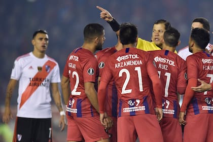 Carrillo aleja a los jugadores de Cerro Porteño, después del primer penal que sancionó en favor de River.