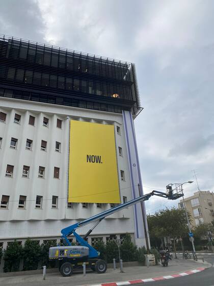 Cartel de la ciudad de Tel Aviv que dice "Now", exige por la vuelta urgente de los rehenes a sus hogares