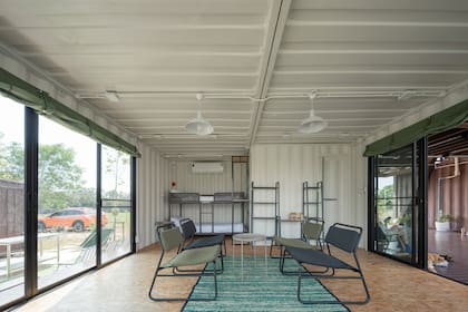 Casa creada con contenedores, dos camas cucheta y un espacio de reunión