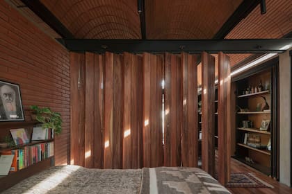 El dormitorio puede resguardarse a través de una serie de paneles de madera móviles.