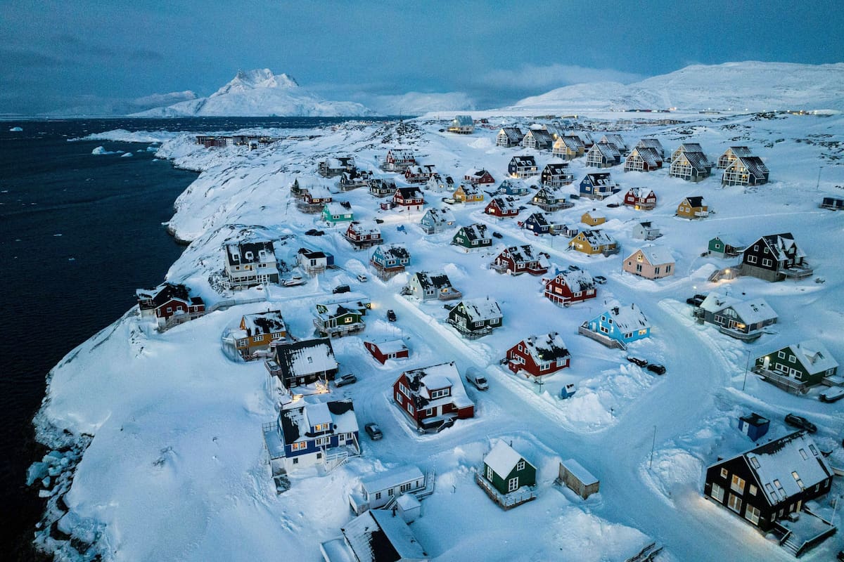Casas cubiertas de nieve en la costa de una ensenada marina en Nuuk, Groenlandia