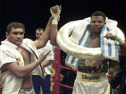 Castro levanta la mano del cubano Juan Carlos Gómez, su vencedor en la pelea por el título mundial crucero, en Alemania, en 2000