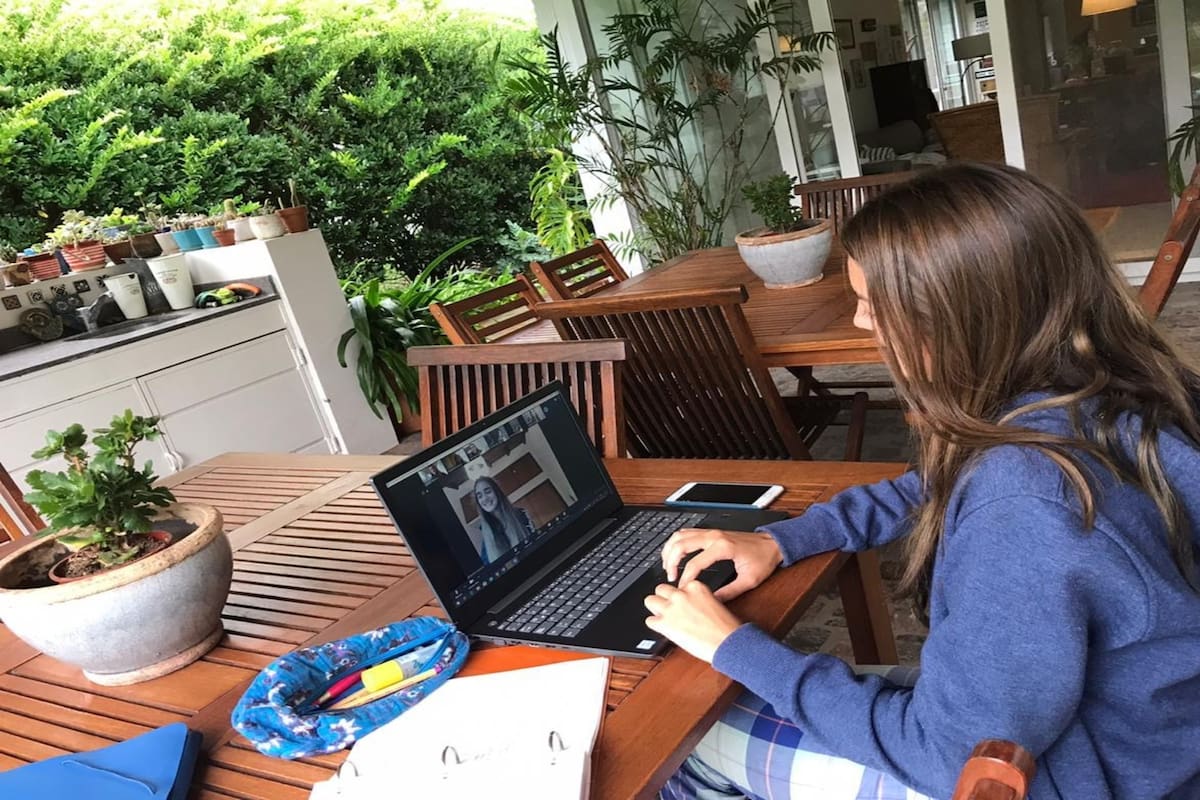 Catalina Munuse, desde la galería de su casa, tomando su clase de Matemática Financiera por videollamada, junto a su docente y al resto de los alumnos
