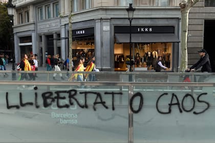 Manifestantes envueltos en banderas caminan por las calles de Barcelona.