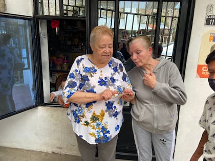 Cecilia Blanca Guernica y Lidia León observan una foto de las primeras reuniones para la fundación del 83