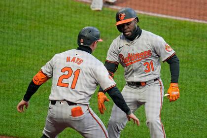Cedric Mullins (31), de los Orioles de Baltimore, celebra con su compañero Austin Hays mientras regresa a la caseta luego de batear un jonrón solitario frente al relevista de los Piratas de Pittsburgh, Hunter Stratton, durante la octava entrada del juego de béisbol en Pittsburgh, el viernes 5 de abril de 2024. (AP Foto/Gene J. Puskar)