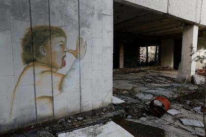 Un grafiti con la imagen de un chico haciendo burlas sobrevivió intacto al paso del tiempo en la pared de un supermercado convertido en ruinas