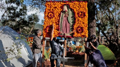 Vistosos arreglos florales se ven a los largo de los cementerios