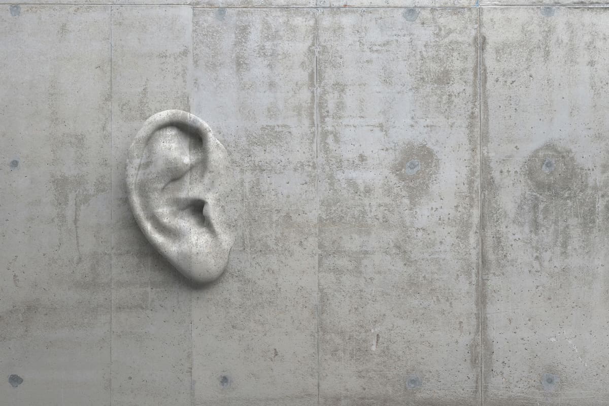 Cement sculpture in the shape of a human ear on a concrete wall. Illustration of the metaphor "Even walls have ears." Creative conceptual modern art with copy space. 3D rendering