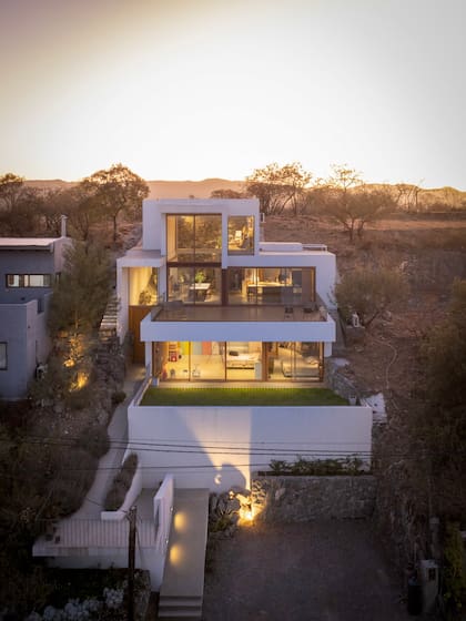 Cerrada atrás y abierta adelante, la casa-estudio, de 260 m2, se apoya por completo contra la montaña.