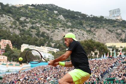 Cerúndolo impacta la pelota en el partido ante Alcaraz; detrás, el imponente marco de Montecarlo