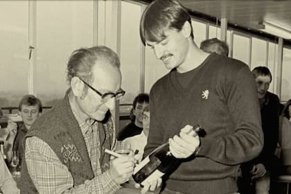 César Milstein firma una botella de champagne a un colega en el Laboratorio de Biología Molecular de Cambridge, el día que se enteró que había ganado el Premio Nobel de Medicina