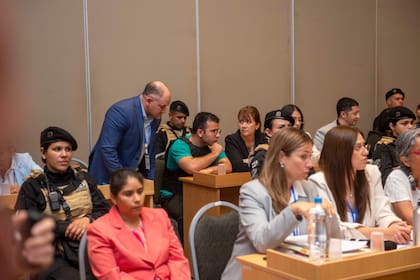 César Sena, de remera verde y chaleco antibalas, con su abogada (a su izquierda) y el abogado de su padre (a su derecha)