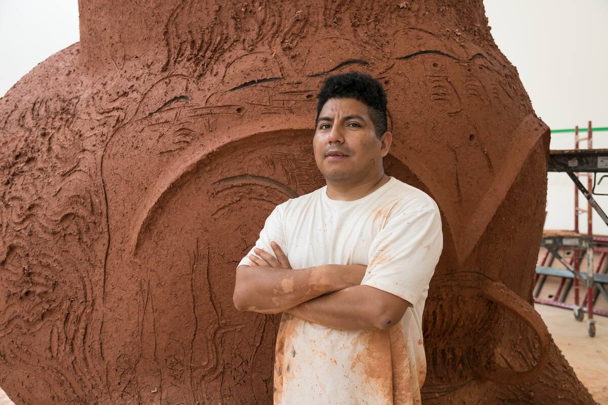 Chaile con su nueva escultura, "La Yunga", que incluye figuras de soldados apuntando con armas