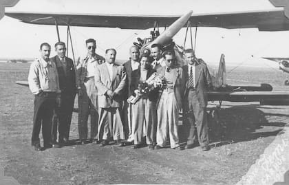 Charito Germanó recibe flores tras batir el récord mundial de loopings en el AeroClub de Carhué. Fuente: Museo Regional “Dr. Adolfo Alsina”.