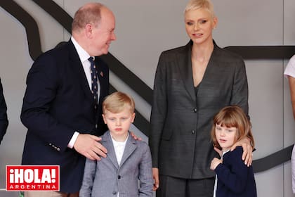 Charlene con el príncipe Alberto II y sus dos hijos, Jacques –con un traje compuesto por bermudas y chaqueta a tono– y Gabriella, con vestido blanco y cardigan de onda navy.