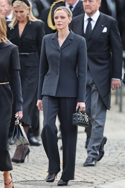 Charlene de Mónaco apostó a un total look Dior: blazer y pantalón confeccionado en lana y seda, stilettos y cartera modelo Lady Small Lady D-Joy. Acompañó con un discreto tocado con red
