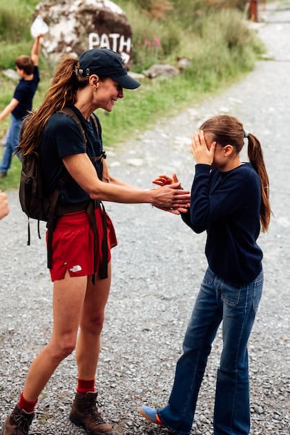 Charlotte, orgullosa del logro que realizó su mamá. En esta imagen, que coincide con el final del desafío, se la ve a la mujer de William con short de North Face; el gorro, la remera y la mochila, de la firma sueca Fjallraven Kanken
