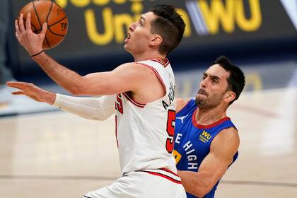 Chicago Bulls guard Ryan Arcidiacono, front, is fouled by Denver Nuggets guard Facundo Campazzo during the first half of an NBA basketball game Friday, March 19, 2021, in Denver. (AP Photo/David Zalubowski)