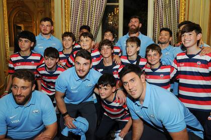 Chicos del club rosarino Old Resian posan junto a algunos rugbiers de los Pumas, como Marcos Kremer y Matías Alemanno, en la embajada de Francia; los jugadores de hasta 14 años participarán en un certamen internacional escolar en Francia en septiembre, justo antes del Mundial.