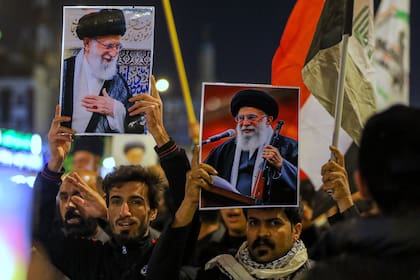 Chiíes iraquíes sostienen imágenes del líder supremo iraní, el ayatolá Alí Jamenei, que murió por un ataque estadounidense en Teherán, durante un funeral simbólico en Najaf, Irak, el domingo 1 de marzo de 2026. (AP Foto/Anmar Khalil)