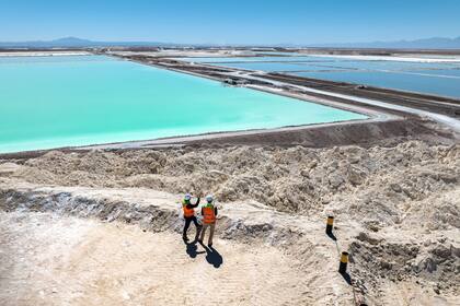 Chile extrae litio de las salinas del desierto de Atacama
SALAR DE ATACAMA, CHILE - 24 DE AGOSTO: En esta vista aérea, los visitantes se paran sobre un gran montículo de subproducto de sal de la producción de litio en una mina en el desierto de Atacama el 24 de agosto de 2022 en Salar de Atacama, Chile. Albemarle Corporation, con sede en Charlotte, Carolina del Norte, está expandiendo las operaciones mineras allí para satisfacer la creciente demanda mundial de carbonato de litio, un componente principal en la fabricación de baterías, cada vez más para vehículos eléctricos. En la Planta Salar, la salmuera natural se bombea desde debajo de vastas salinas a una serie de estanques de evaporación. Durante un proceso de 18 meses, el líquido se movió a través de 15 estanques y eventualmente cambió de azul oscuro a amarillo brillante con una concentración de litio del 6 por ciento. Luego se transporta en camiones a una planta química de Albemarle en Antofagasta, donde se procesa en polvo de carbonato de litio apto para baterías y se envía internacionalmente. El proceso de evaporación produce grandes cantidades de subproductos de sal, muchos de los cuales luego se reprocesan y venden. Chile es el segundo mayor productor mundial de litio, después de Australia