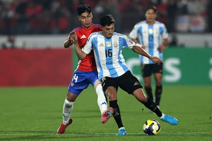 Nahuel Molina disputa la pelota con Dario Osorio