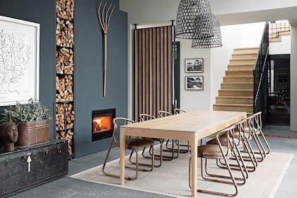 Chimenea (Charnwood). Mesa ‘Harris’ (James Mudge). Sillas de acero tubular con asiento tapizado en cuero (Studio 19). Lámparas colgantes (Loft Living).