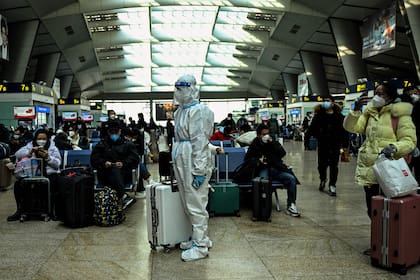 Un pasajero con equipo de protección en una estación de tren en Beijing el 28 de diciembre de 2022