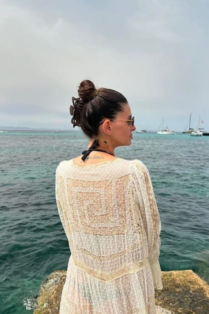 China Suárez posó de espaldas al mar con una bikini negra y un kimono blanco con detalles bordados.