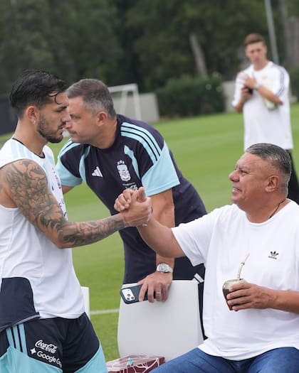 Chiqui Tapia tomando mate durante el entrenamiento de la selección argentina, saludando a Leandro Paredes
