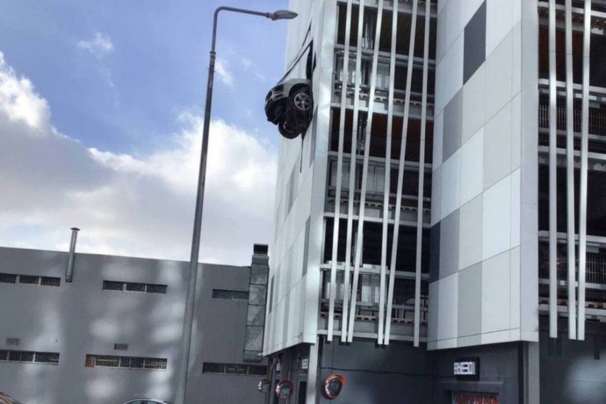 Chocó contra la pared de un edificio de estacionamiento y su auto quedó colgado de la estructura Foto: Departamento de Transporte de Moscú