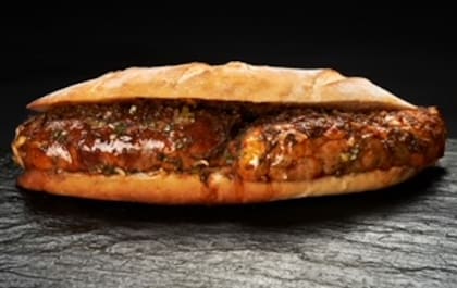 Choripán de pacú en pan baguette, con chimichurri y salsa criolla.