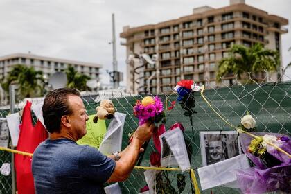 Chris Jeffers pone flores en un memorial improvisado a las víctimas del derrumbe de Surfside